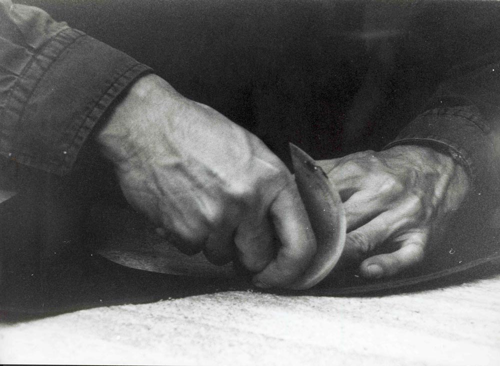 Hände beim schneiden von Leder